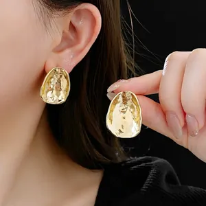 Irregular textured gold stud earrings with a minimalist hammered pebble design for women