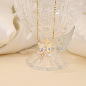 Detail of gold butterfly pendant with iridescent crystals against a white silk background