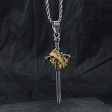 Close-up of silver sword and gold crown pendant with 925 hallmark on metal clasp