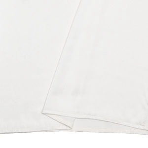 Gros plan sur le tissu en satin blanc lisse et les coutures soignées de l'ourlet