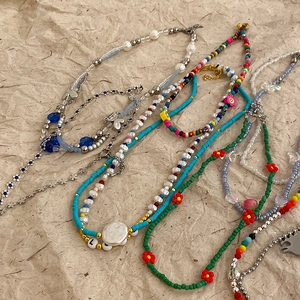 Colorful mixed bead necklaces with irregular geometric charms on aesthetic brown paper