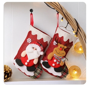 Detail of burlap Christmas stockings with 3D characters on a cozy wooden wall rack
