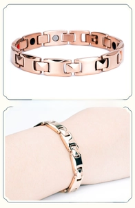 Detail of rose gold magnetic therapy bracelet with H-link design and functional stone inlays