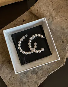 Dettaglio orecchini a cerchio con perle, completi di scatola regalo e custodia in velluto