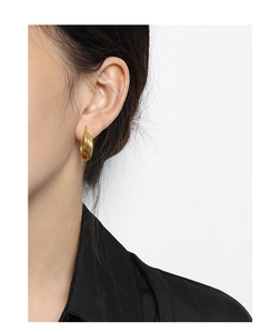 Close-up of minimalist gold multilayer line earrings worn by a model in a side profile view