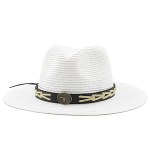 Close-up of white panama hat with black leather band and bronze bull head emblem