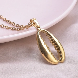 Close-up of golden shell pendant necklace with detailed texture and 18k plating