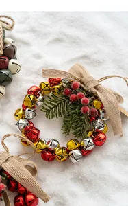 Close-up of Christmas bell wreath with red berries, pine needles and a burlap bow decoration