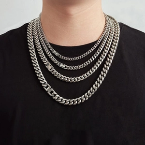 Macro view of tiered silver stainless steel Cuban link necklaces with jewelry clasps
