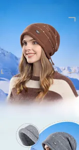 Détail de la maille d'un bonnet slouchy rayé épais avec doublure douce et petit logo
