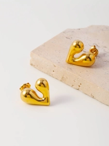 Detail of gold heart stud earrings with an irregular liquid metal lava design