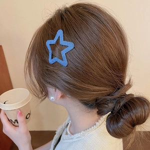 Blue star-shaped hair clip with denim fabric texture worn on female model's hair