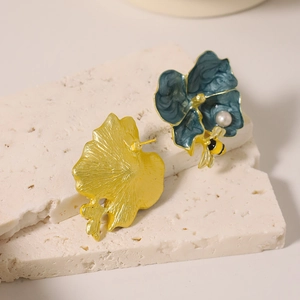 Vintage enamel flower and bee earrings with freshwater pearls on white marble stone
