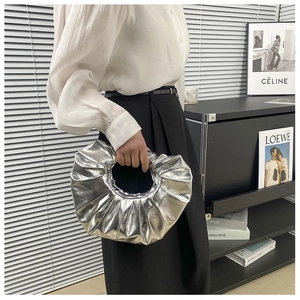 Makroansicht der silbernen metallischen Falten-Handtasche mit Hochglanz-Spiegel-Finish