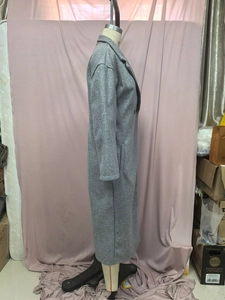 Détail d'un long manteau en laine gris foncé avec revers classique et poche latérale