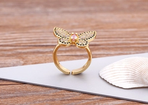 Close-up of 18K gold butterfly ring with colorful zircons and adjustable open band