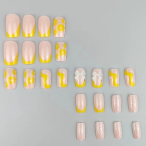 Press-on nails set with yellow floral patterns, 3D bows, and pink glitter finishes