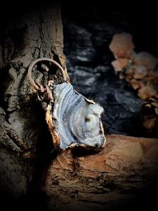 Détail macro du pendentif irrégulier en agate solaire avec bords plaqués cuivre