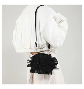 Détails du sac bandoulière en cuir mat noir avec de longues franges et des anneaux dorés