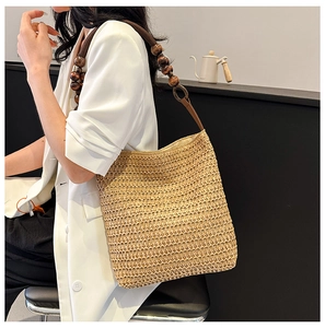 Detail of khaki straw woven tote bag featuring dark brown circular wooden bead straps