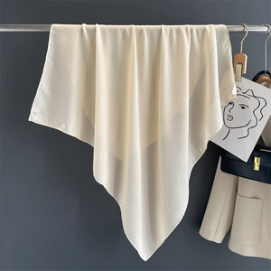 Detail view of beige cotton linen scarf hanging to show soft texture and natural drape