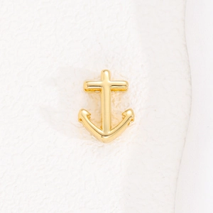 Macro detail of a golden anchor charm pendant for a 10mm mesh strap bracelet