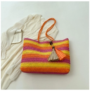 Detailed macro view of colorful rainbow straw tote bag with decorative tassel charm