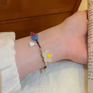 Bracelet tressé avec fleur en résine et perles en cœur et pompon de style vacances