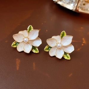 Macro view of French vintage enamel flower earrings with pearls and gold edges