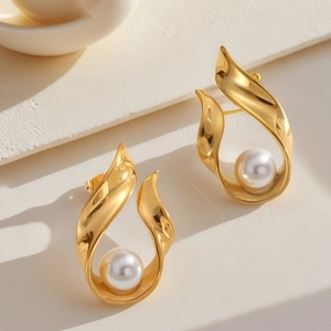 French vintage U-shape gold earrings with white pearls on a minimalist background