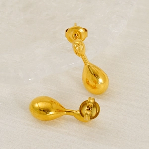 Polished gold teardrop earrings with a minimalist round base on textured white background