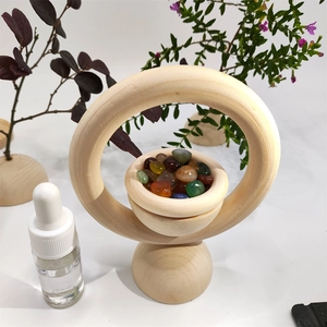 Close-up of wooden essential oil diffuser ring with colorful crystals on a white background