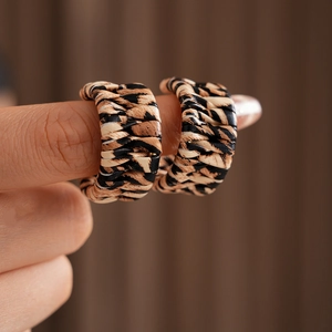 Close-up of C-shaped leopard print earrings with leather texture on a female model