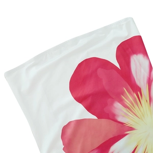 Detailed close-up of the red floral print on the white strapless maxi dress fabric