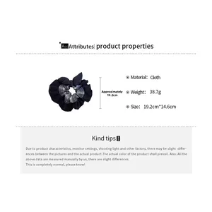 Detail view of navy fabric hair scrunchie with dimensions 19.2cm by 14.6cm