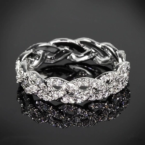 Macro shot of rose gold interlaced band ring with shimmering pavé diamond setting