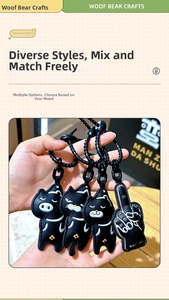 Detail of black leather cat and pig bag charms with fine stitching and golden accents