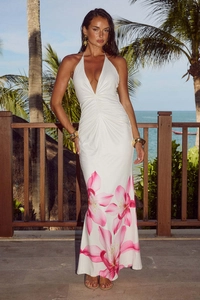 Detail of white halter neck dress with pink floral print and waist pleats at the beach