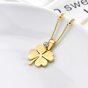 Collier trèfle en acier titane doré avec chaîne à billes sur plateau en céramique