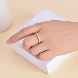Minimalist gold frosted stainless steel spinning ring for women on a jewelry box