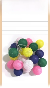 Close-up of colorful cotton ball string lights in pink blue and yellow for home decor