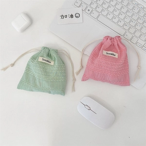 Detail of pink and green drawstring pouches with textured seersucker fabric and cotton cords