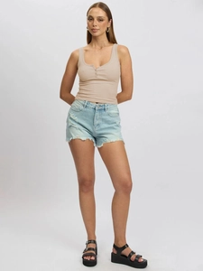 Detail shot of light beige ribbed knit vest paired with light blue frayed denim shorts