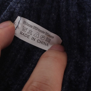 Detail of care label showing material blend on cable knit hat with 50% Viscose