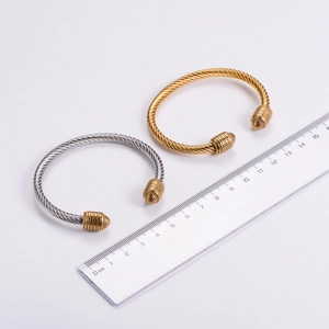 Macro shot of twisted cable stainless steel bangles with embossed decorative end caps
