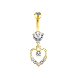 Dettaglio di un piercing all'ombelico dorato con zircone a cuore e barra curva lucida