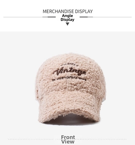 Dettaglio del cappellino in pile beige con ricamo vintage sulla parte anteriore