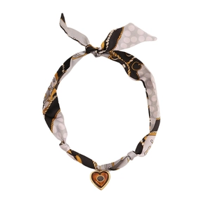 Elegant silk scarf necklace featuring chain patterns and a gold heart pendant on white