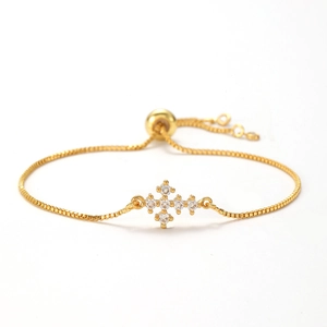 Detail of gold box chain bracelet featuring a cross pendant with micro-pave zircons