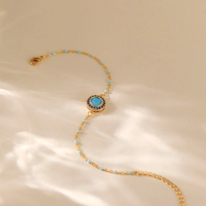 Bohemian gold chain bracelet with turquoise beads and circular eye-shaped pendant